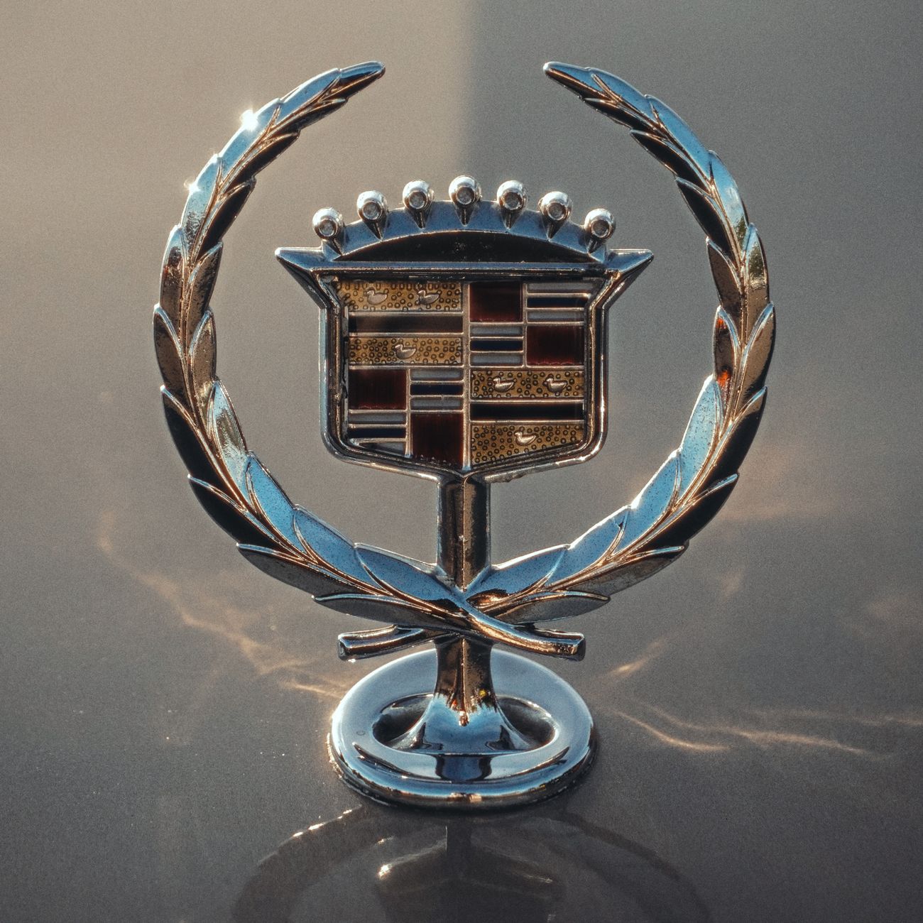 A vintage chrome car emblem with a reflective finish