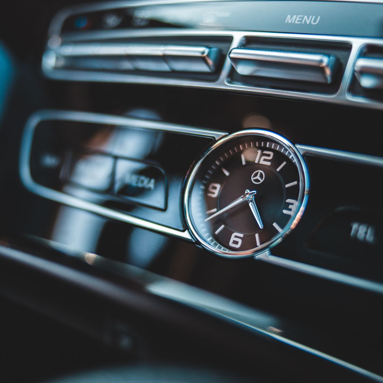 A luxury car dashboard clock, close up
